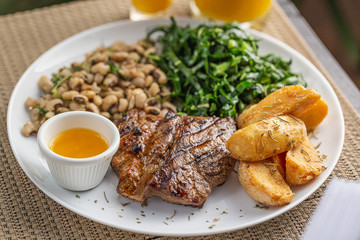 Typically Brazilian food with bottle butter, beans, steak, potatoes and cabbage
