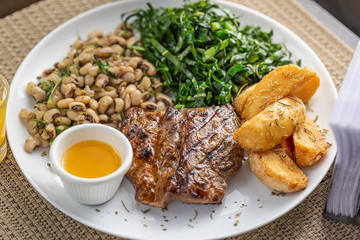 Typically Brazilian food with bottle butter, beans, steak, potatoes and cabbage