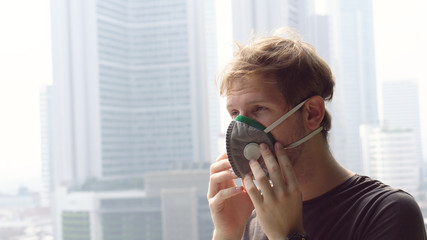 Coronavirus Epidemic - Man Putting on Respirator Mask To Protect Against Illnes