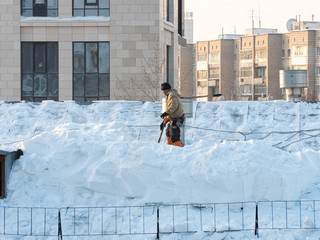 Hard work to remove snow from the roof of a building