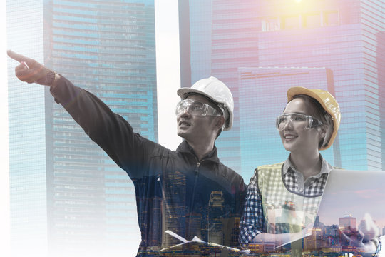 Smiling Manufacture Worker Asian Man And Woman Stand Confident With The Background Of White Sky And Building Tower. Concept Of Industry Factory People With Art Flare Background.