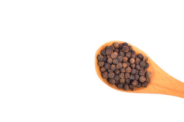 Black peppers on wooden spoon on white background.