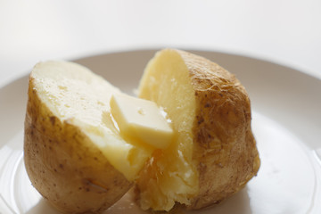 あつあつのジャガイモにバターを塗る
