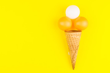 Ping pong ball in ice cream waffle cone on yellow background in minimal style. Concept sports entertainment. Top view Copy space Template for text or your design.