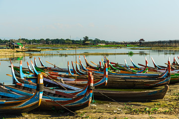 Fototapeta na wymiar unique wooden vintage boats parking on shore with amazed nature scenic landscape at U Bein Bridge, Amarapura , most popular tourist attraction in Myanmar