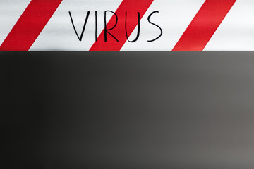 Label virus. Red and white warning tape with the inscription virus close up on black background....
