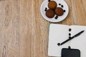 Flat lay composition with notepad, cup of coffee and breakfast cookies. Record a plan for the day. Morning workplace