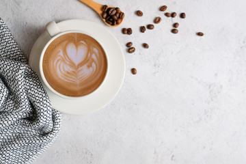 hot coffee with latte art on white marble background with the bean and decorative flat lay style.