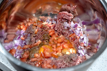 Preparing homemade hamburgers. Ingredients in a bowl before mixing. Home made food and cooking concept.