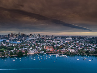 Fototapeta na wymiar Panoramic drone aerial view over Sydney harbour on a cloudy sunset afternoon showing the nice colours of the harbour foreshore