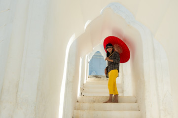 Asian tourist woman holding red umbrella enjoy sightseeing the most beautiful Pahtodawgyi Paya temple ,Sagaing Region, Myanmar © Jack Tamrong