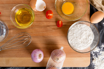 The ingredients in the cooking, placed on wooden tables, eggs, flour and vegetable oil are the main components.