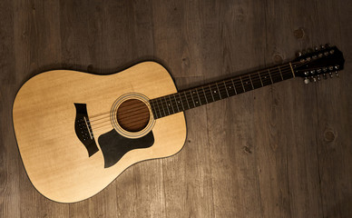 Full 12-string acoustic guitar on a brown wooden floor