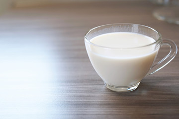 Soy milk in glass on wooden background