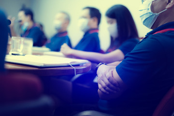 Blurry image of Business people wear masks to prevent Coronavirus (Covid-19) in meeting room. Startup business team brainstorming on meeting workshop.