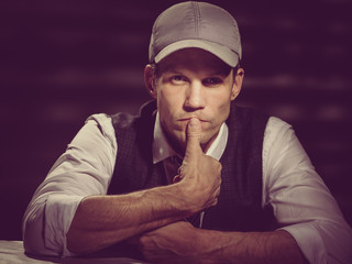 Toned photo of thoughtful stylish man in retro outfit