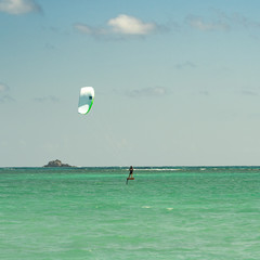 Kiteboarders and windsurfers skipping across the aqua waters of windward Oahu Hawaii