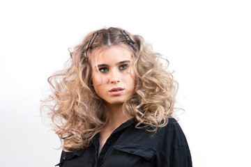 Blonde girl with long and volume shiny wavy hair. Beautiful model woman with curly hairstyle.