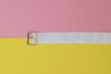 A white belt with a metal buckle separates the yellow and red areas of the image. The concept of...