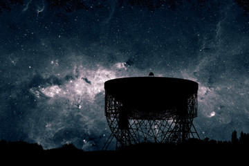 Radio telescope dish silhouette at night with the centre of the  Milky Way stars in the background....