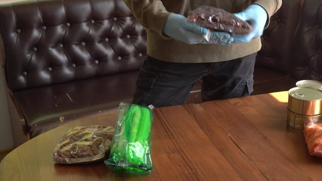 Cleaning and disinfecting of food packaging surface using antiseptic alcohol wipes after grocery shopping. Disinfection Efforts Against COVID-19 at home. Hands in gloves. Buying at the Supermarket