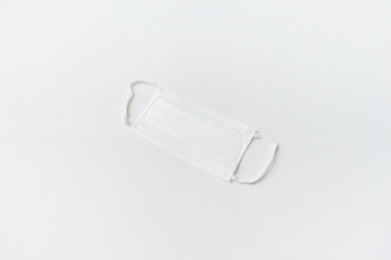 Surgical mask with rubber ear straps. Typical 3-ply surgical mask to cover the mouth and nose. Procedure mask from bacteria. Protection concept. top view. white background.