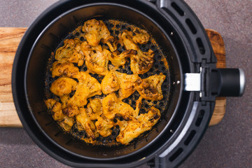 plant-based food, vegan buffalo cauliflower florets in air fryer basket