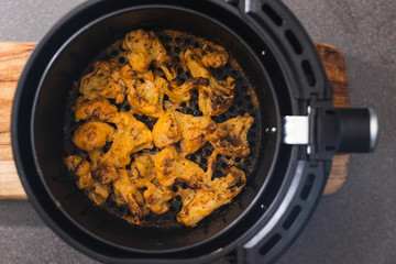 plant-based food, vegan buffalo cauliflower florets in air fryer basket