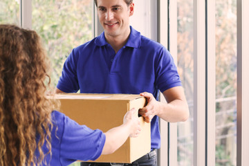 Delivery man delivery or send the box to customer, hands of postman carry the goods package and sent to receiver at home