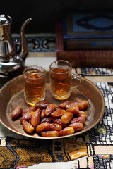 Dates fruit and Islamic Book Koran on carpet background