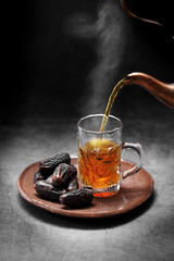 Arab tea and dates fruit  on a concrete background with a blank space for a text