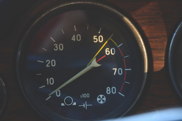 Closeup on a tachometer of a vintage car in sunset light