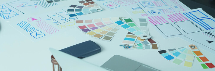 Designers man drawing ui/ux designers working and designing user interface for website and application, working together with partner planning and brainstorming sketch designs with computer laptop.