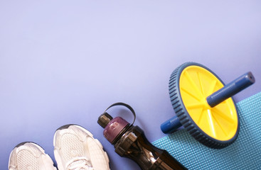 Composition with sport inventory on a blue background. Sport concept flat lay. Sports shoes for health and botle for water. Copy space, banner.