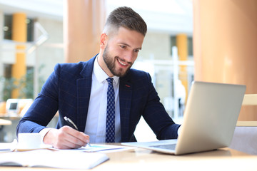 Obraz premium Portrait of young man sitting at his desk in the office.