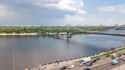 Aerial top view of Kiev city from above, Kyiv skyline, hills, pedestrian Park bridge and Dnieper river cityscape in spring, Ukraine
