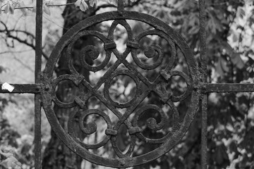 A beautiful black, cast-iron, openwork, forging round element with a round middle in its center - at the large gate.