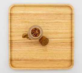 Rock sugar in mini glass tank and cork lid on wooden cutting board and empty space for add on isolated on white.