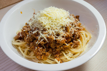 Close-up view of spaghetti bolognese with parmesan cheese.