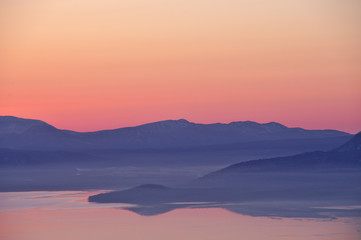 Fototapeta na wymiar 夜明けの湖、山並みのシルエット。屈斜路湖、北海道、日本。