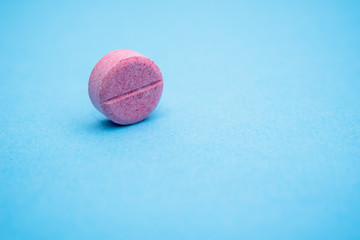 one round pink pill on the rib, close up