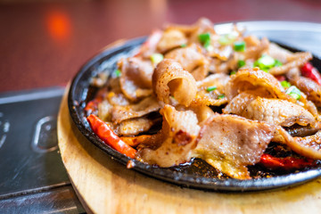 Spicy chinese food in white plate on wooden table