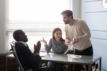 Angry man pointing an error in document to employee. Displeased family upsetting loss of money and arguing with office african american businessman. Family problem with credit contract at meeting.