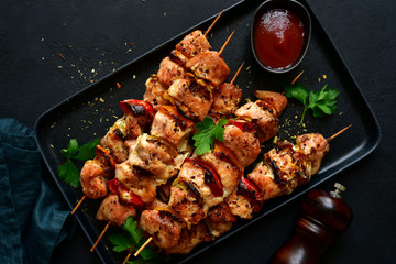 Grilled chicken kebab with vegetables and greens. Top view with copy space.