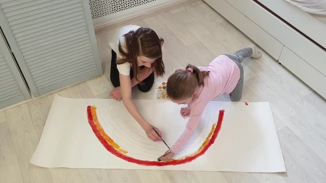 two sisters paint a rainbow with watercolors as a symbol of hope while fighting the coronavirus, stay at home-social media campaign
