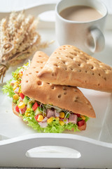 Sandwich with lettuce, pepper, corn, and ham