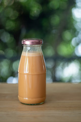 Cold Thai milk tea in a glass bottle