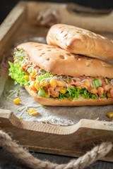 Sandwich with green lettuce, pepper, corn, and ham