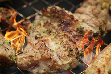 Pork steaks on the grill with flames