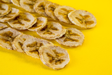 Dried banana chips, sliced in thin circles. Background for healthy and natural nutrition.